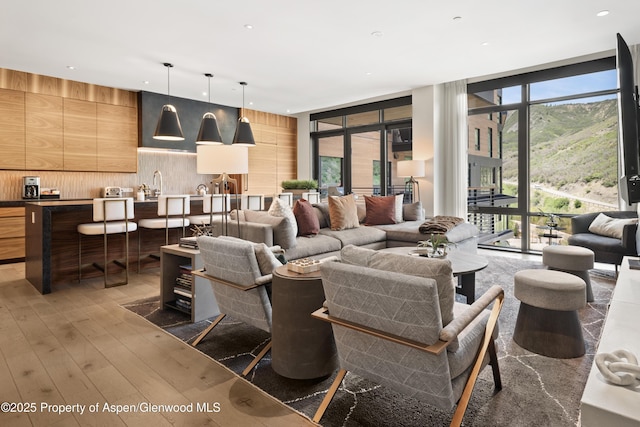 77 Wood Rd Unit 505E, Snowmass Village, CO 81615 - living area with light wood-style floors, wood walls, a wall of windows, plenty of natural light, and recessed lighting