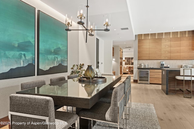 77 Wood Rd Unit 505E, Snowmass Village, CO 81615 - dining room with wine cooler, light wood finished floors, and a chandelier
