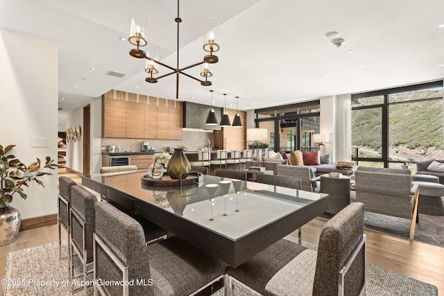 77 Wood Rd Unit 505E, Snowmass Village, CO 81615 - dining room with light wood-type flooring, wine cooler, a chandelier, and recessed lighting