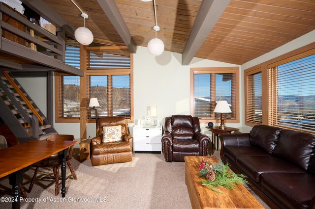 carpeted living room featuring lofted ceiling with beams and wood ceiling