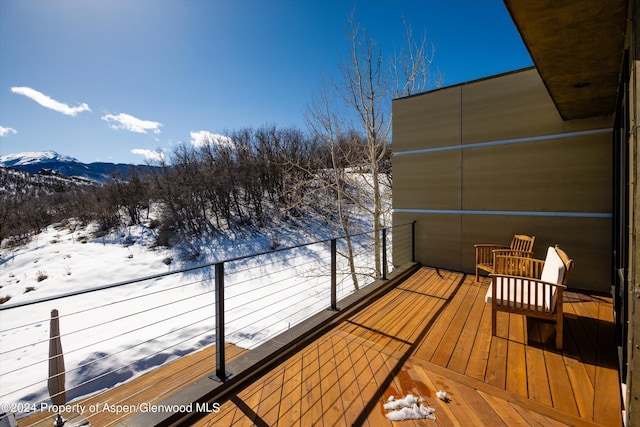 snow covered deck with a mountain view