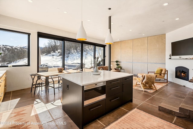 kitchen featuring pendant lighting, a center island, and dark tile patterned floors