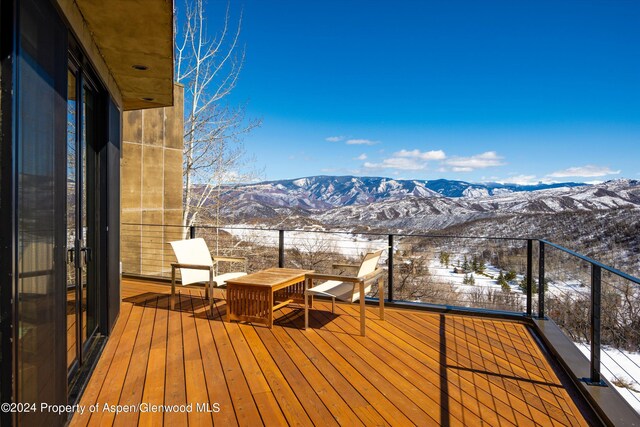 snow covered deck with a mountain view