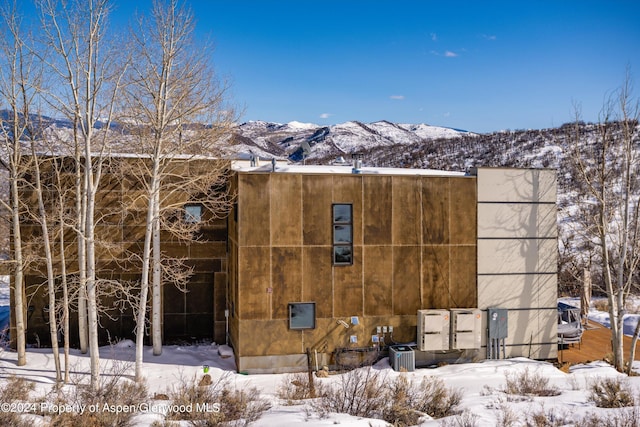 snow covered house featuring a mountain view