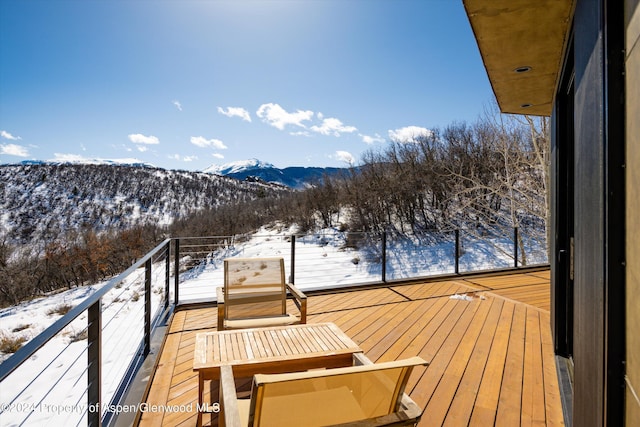 snow covered back of property featuring a mountain view