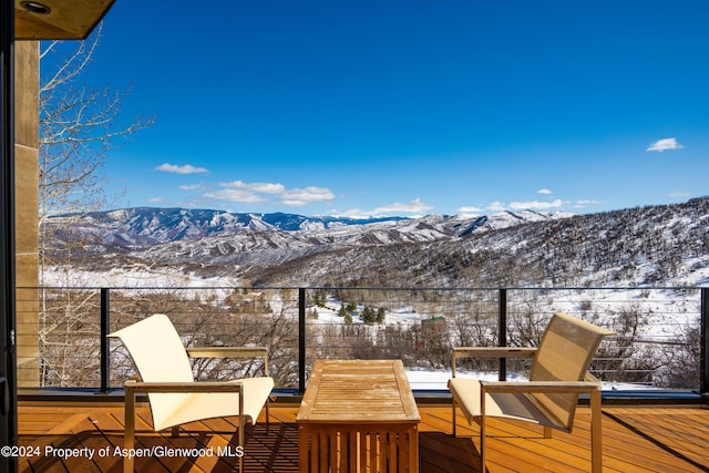 snow covered deck with a mountain view