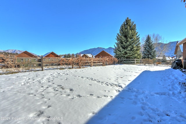 yard covered in snow with a mountain view