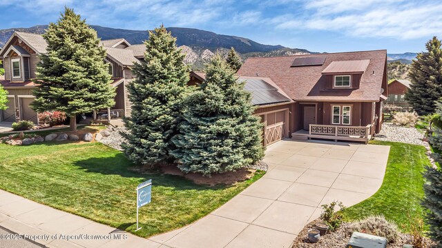 168 Blackhawk Dr, New Castle, CO 81647 - view of front of property featuring solar panels, a mountain view, concrete driveway, and a front yard