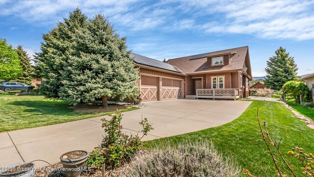 168 Blackhawk Dr, New Castle, CO 81647 - view of front of property with an attached garage, a front lawn, solar panels, driveway, and board and batten siding