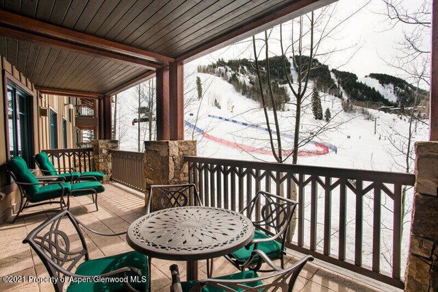 snow covered deck featuring outdoor dining space