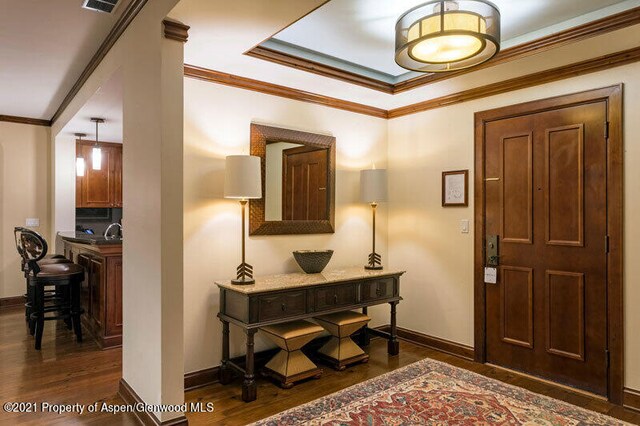 entrance foyer featuring baseboards, dark wood-style flooring, and crown molding