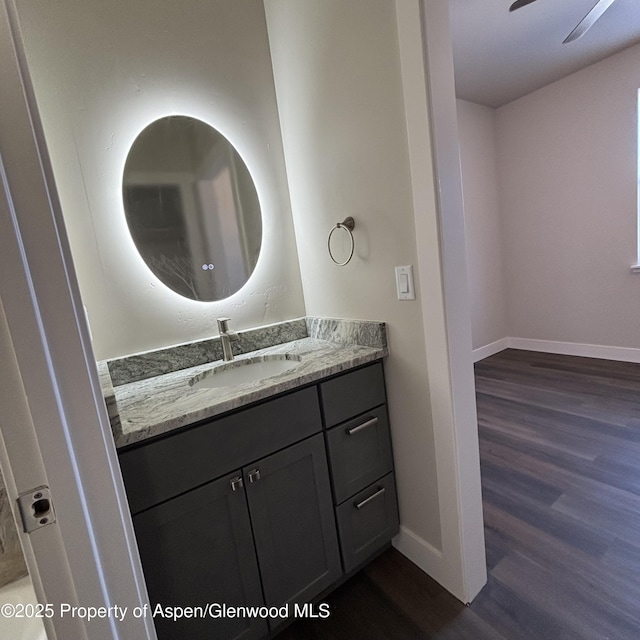 bathroom with wood finished floors, vanity, and baseboards