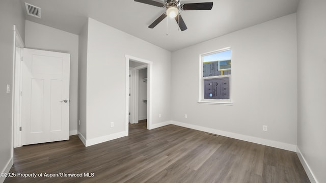 unfurnished bedroom with dark wood-style flooring, visible vents, and baseboards