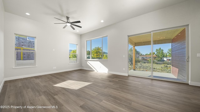 spare room with dark wood-style flooring, recessed lighting, and baseboards