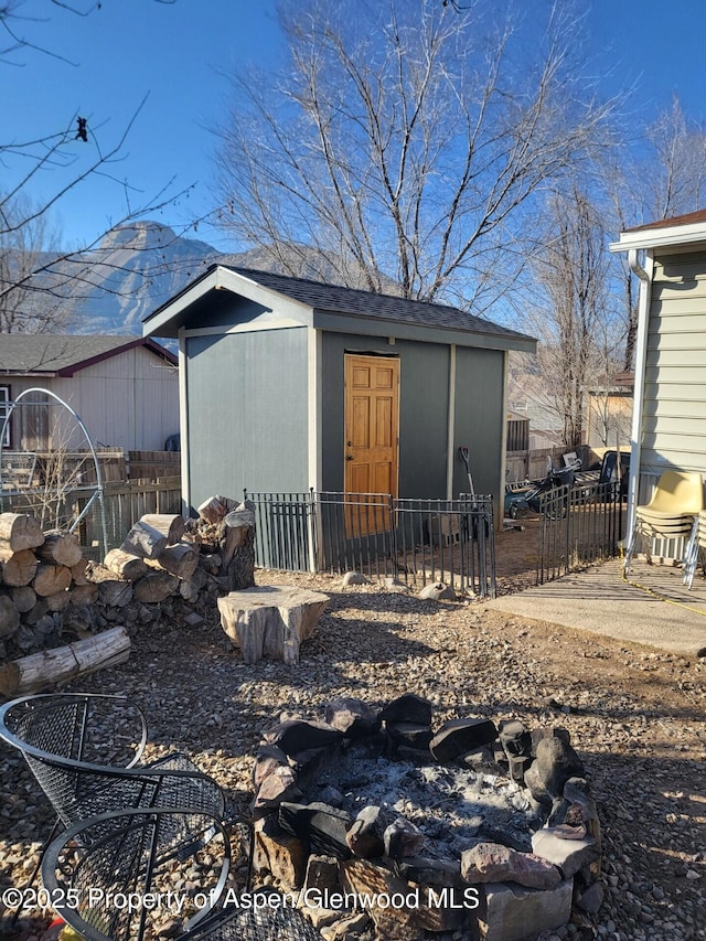 rear view of house featuring a mountain view and a storage unit