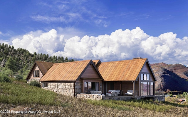 902/904 Sopris Creek Rd, Basalt, CO 81621 - view of front of home with stone siding, a mountain view, and a chimney