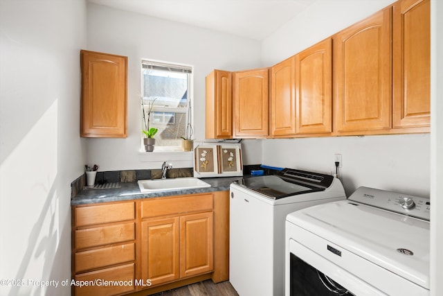 washroom with sink, dark wood-type flooring, cabinets, and independent washer and dryer