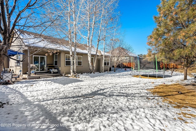 snow covered house with a trampoline