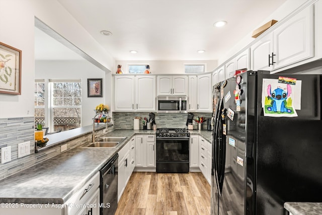 kitchen featuring sink, light hardwood / wood-style flooring, white cabinets, and black appliances