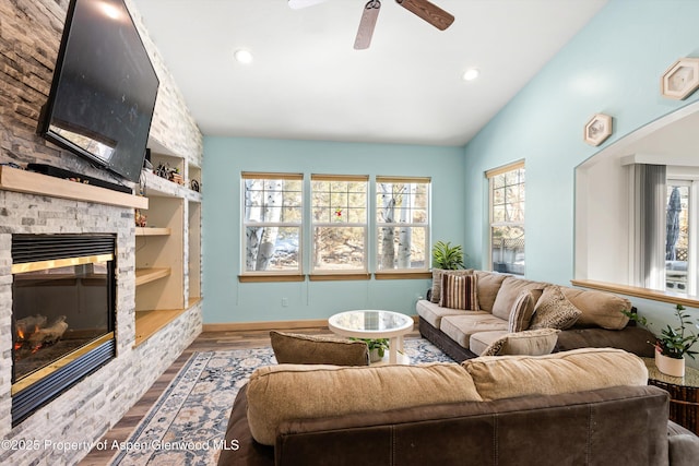 living room with lofted ceiling, built in features, ceiling fan, a fireplace, and hardwood / wood-style floors