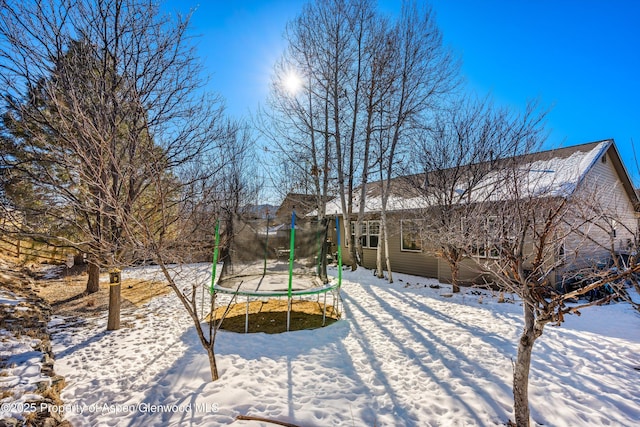 snow covered property with a trampoline