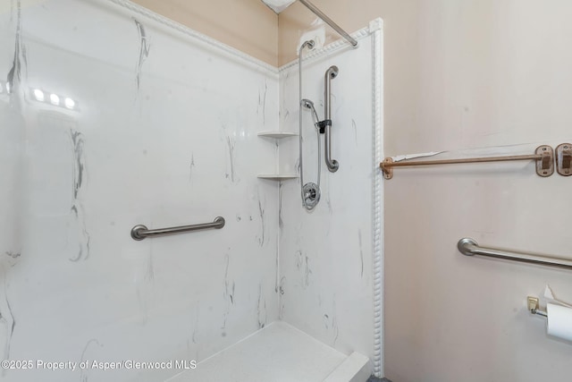 bathroom featuring a marble finish shower