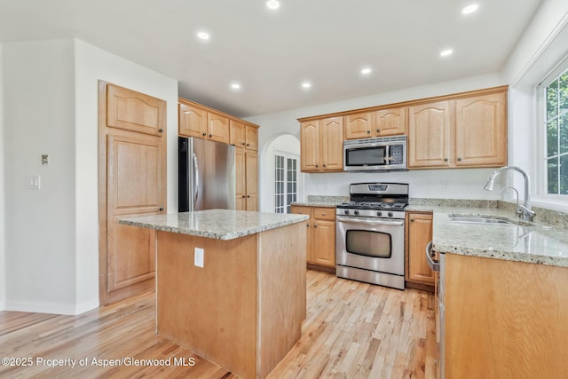 1020 Alta Vista Dr, Craig, CO 81625 - kitchen with stainless steel appliances, light wood-style flooring, light stone countertops, light brown cabinets, and a center island
