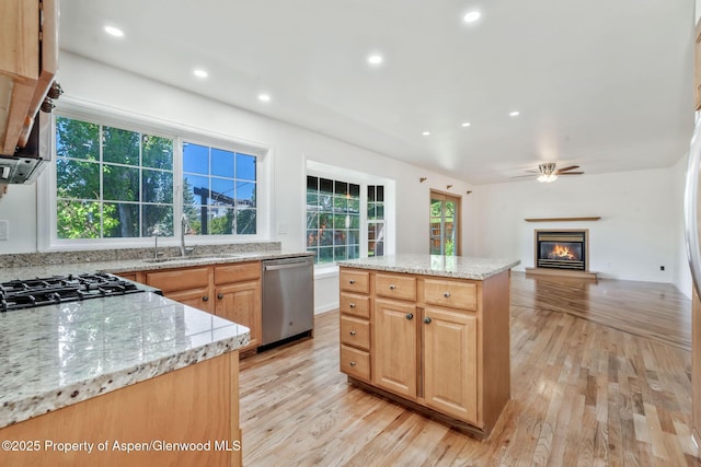 1020 Alta Vista Dr, Craig, CO 81625 - kitchen with dishwasher, a glass covered fireplace, light wood-style floors, light stone counters, and recessed lighting