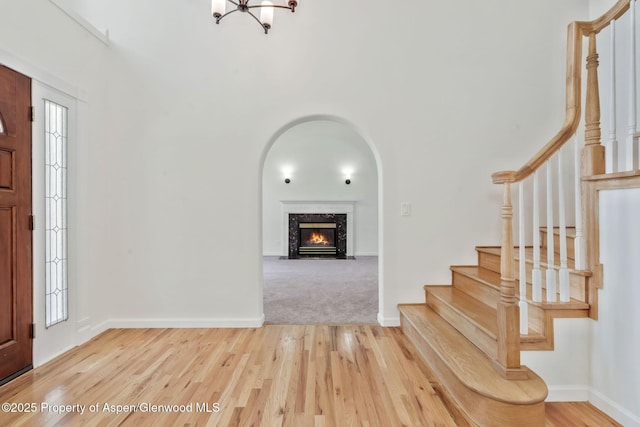 1020 Alta Vista Dr, Craig, CO 81625 - entrance foyer featuring stairs, a high end fireplace, wood finished floors, a chandelier, and healthy amount of natural light
