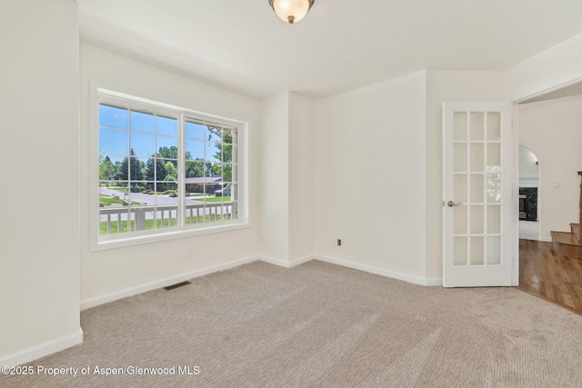 1020 Alta Vista Dr, Craig, CO 81625 - empty room featuring carpet floors, arched walkways, and french doors