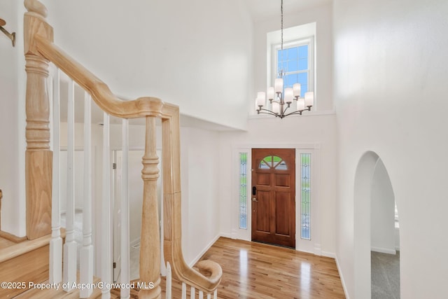 1020 Alta Vista Dr, Craig, CO 81625 - entryway with a towering ceiling, wood finished floors, a chandelier, stairway, and arched walkways