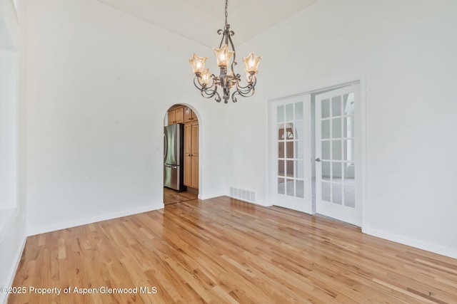 1020 Alta Vista Dr, Craig, CO 81625 - unfurnished dining area with arched walkways, a chandelier, and light wood-type flooring