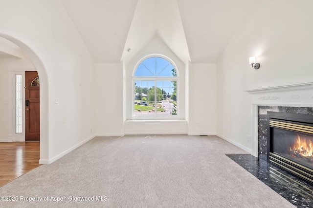 1020 Alta Vista Dr, Craig, CO 81625 - unfurnished living room featuring carpet floors, a fireplace, arched walkways, and lofted ceiling