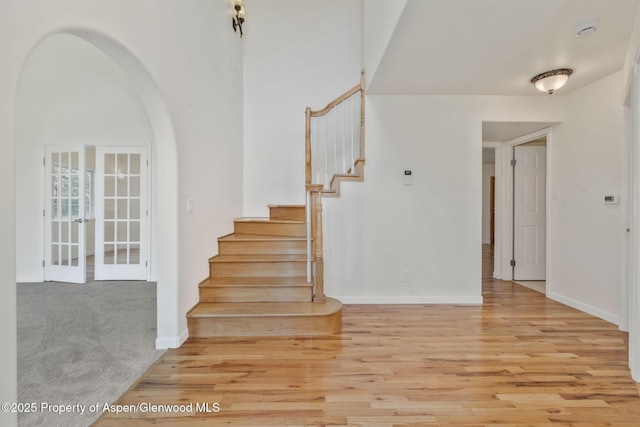1020 Alta Vista Dr, Craig, CO 81625 - stairway featuring arched walkways, wood finished floors, and french doors