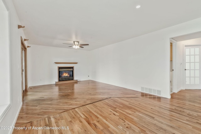 1020 Alta Vista Dr, Craig, CO 81625 - unfurnished living room with a ceiling fan, light wood-style flooring, and a glass covered fireplace