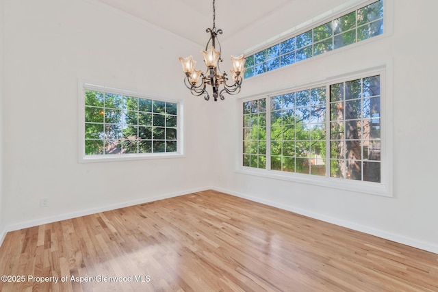 1020 Alta Vista Dr, Craig, CO 81625 - empty room featuring a chandelier, plenty of natural light, and wood finished floors