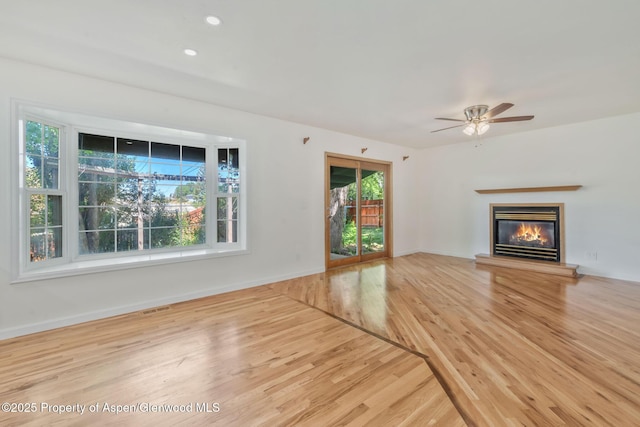 1020 Alta Vista Dr, Craig, CO 81625 - unfurnished living room featuring wood finished floors, a glass covered fireplace, a ceiling fan, and recessed lighting