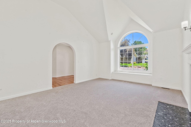 1020 Alta Vista Dr, Craig, CO 81625 - unfurnished living room with carpet floors, high vaulted ceiling, and arched walkways