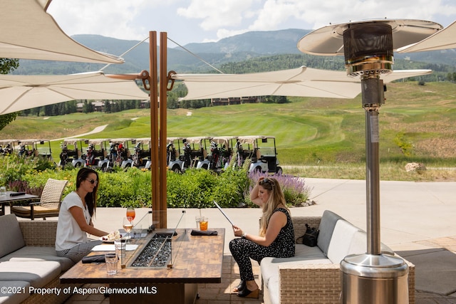 view of patio with a mountain view and an outdoor living space with a fire pit