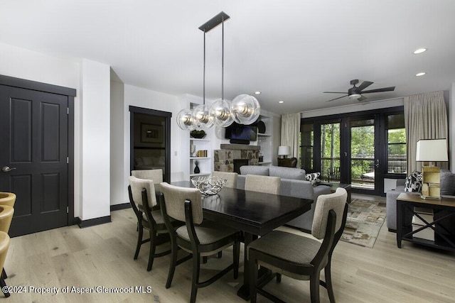 dining area featuring light wood-style flooring, ceiling fan, a fireplace, and recessed lighting