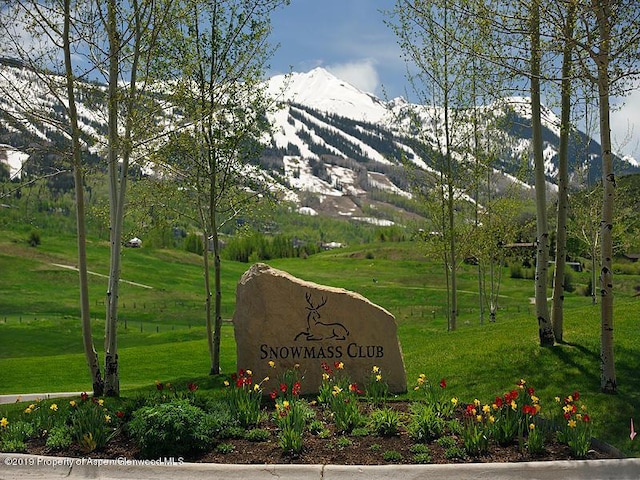 community sign featuring a yard and a mountain view