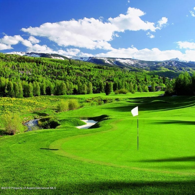 surrounding community with a mountain view and view of golf course