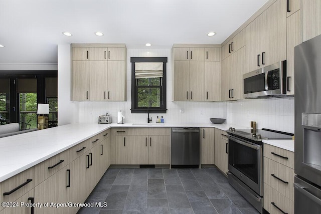 kitchen featuring a sink, appliances with stainless steel finishes, light brown cabinetry, and a healthy amount of sunlight