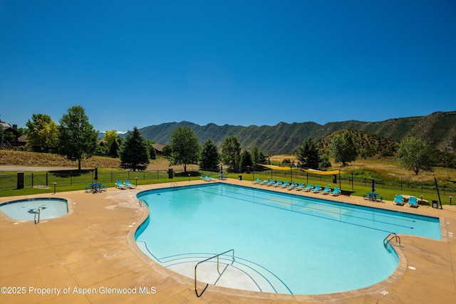 pool featuring a yard, a mountain view, fence, and a patio area