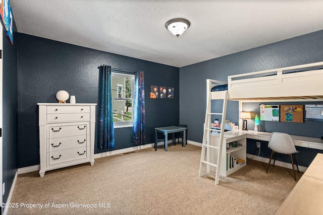 carpeted bedroom featuring a textured ceiling, a textured wall, and baseboards
