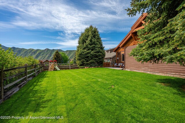 152 Blackhawk Dr, New Castle, CO 81647 - fenced backyard with a playground, a patio area, and a mountain view