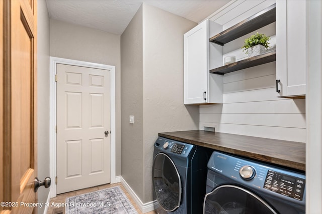 152 Blackhawk Dr, New Castle, CO 81647 - laundry room featuring cabinet space, independent washer and dryer, light tile patterned flooring, a textured wall, and baseboards