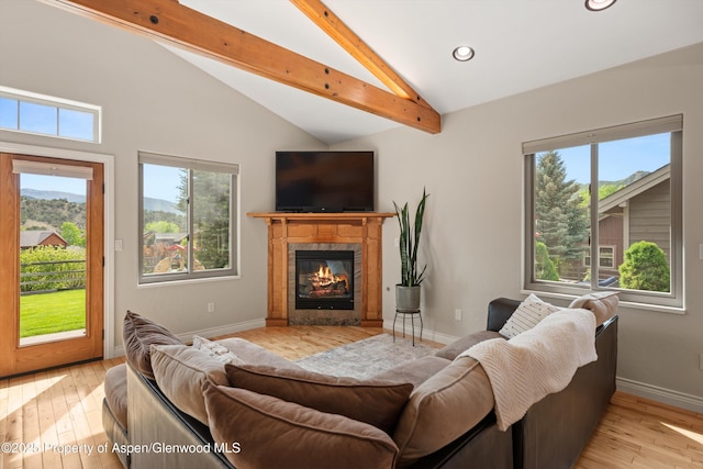 152 Blackhawk Dr, New Castle, CO 81647 - living area with beam ceiling, plenty of natural light, light wood-style floors, a tiled fireplace, and baseboards