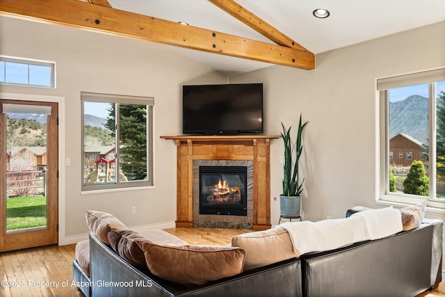 living room with recessed lighting, vaulted ceiling with beams, a high end fireplace, baseboards, and hardwood / wood-style flooring