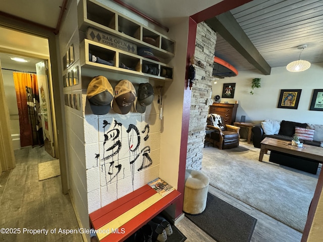 mudroom with beamed ceiling and wood finished floors